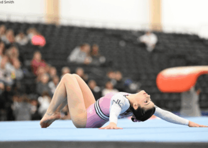 Morgan Reihl poses lying on the floor with her legs bent and her head back and arms back.