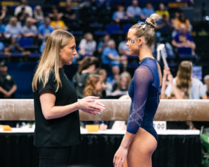 Utah State assistant gymnastics coach Olivia Trautman coaches an athlete during the 2026 Baton Rouge regional