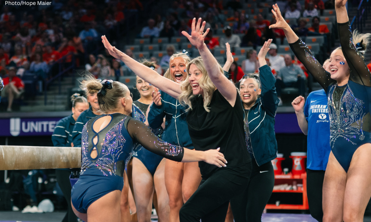Brynlee Anderson prepares to hug her coach after a beam routine as her teammates celebrate around her. 