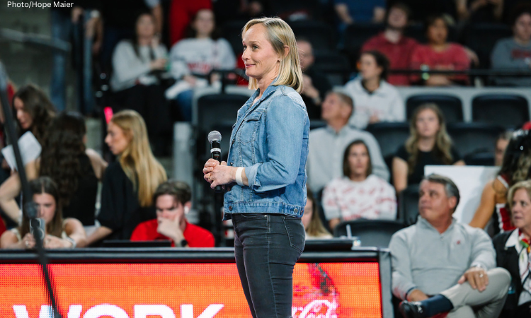 Georgia alum Karen Lichey stands in Stegeman Coliseum with a microphone in her hands. 