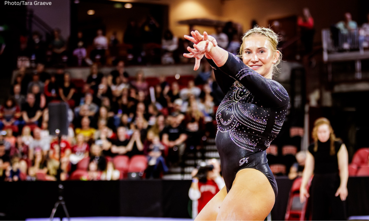 Kiley Rorich poses during her floor routine with both arms out in front of her and one arm crossed in front of the other. 