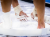 Close-up shot of gymnast chalking up in chalk bucket.