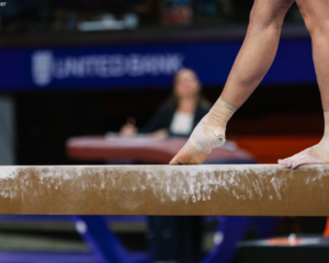 Gymnast stands on the beam with one foot pointed in front of them.