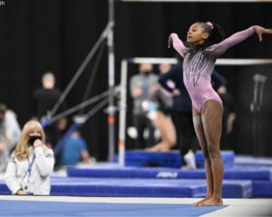 Ariana Barksdale stands in the corner of the floor with both arms up.
