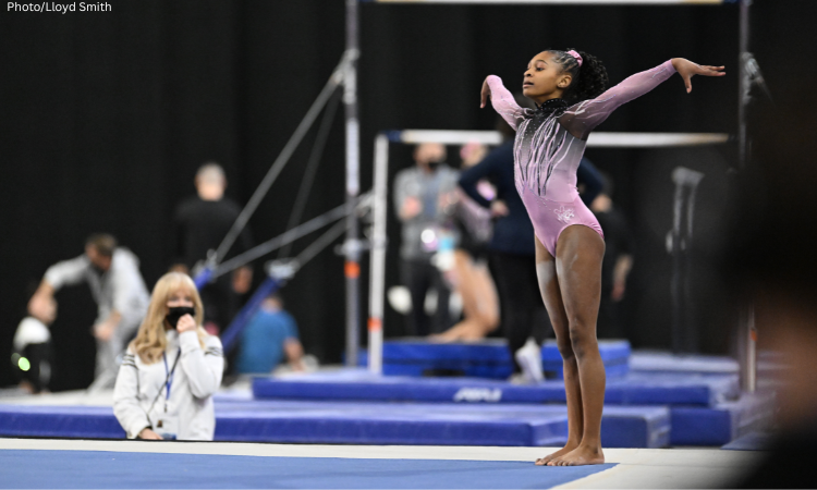 Ariana Barksdale stands in the corner of the floor with both arms up.